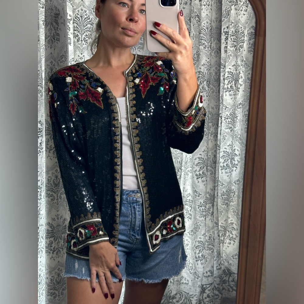 Vintage women’s black silk sequin evening jacket with red floral design.